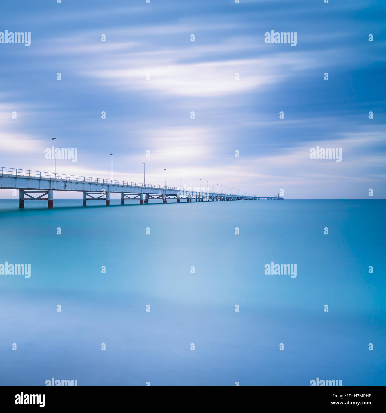 Sur le quai industriel horizon de mer. Vue de côté. Photos à longue exposition dans un jour nuageux. Banque D'Images