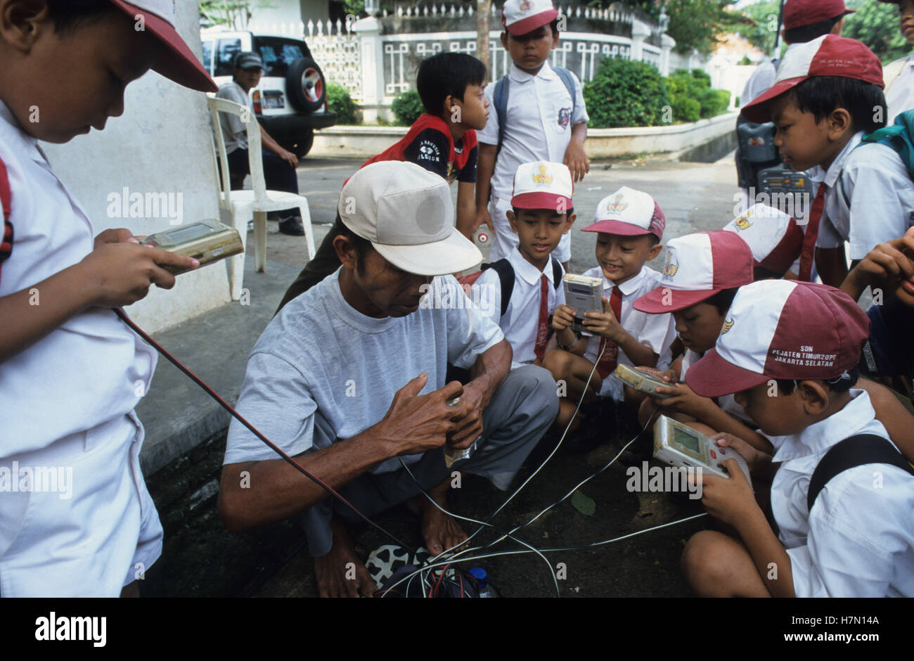 INDONÉSIE Java, Jakarta, les enfants jouant aux jeux Nintendo game boy chez Street vendeur, Game Boy est une console de jeu portable 8 bits, développée par Gunpei Yokoi Banque D'Images