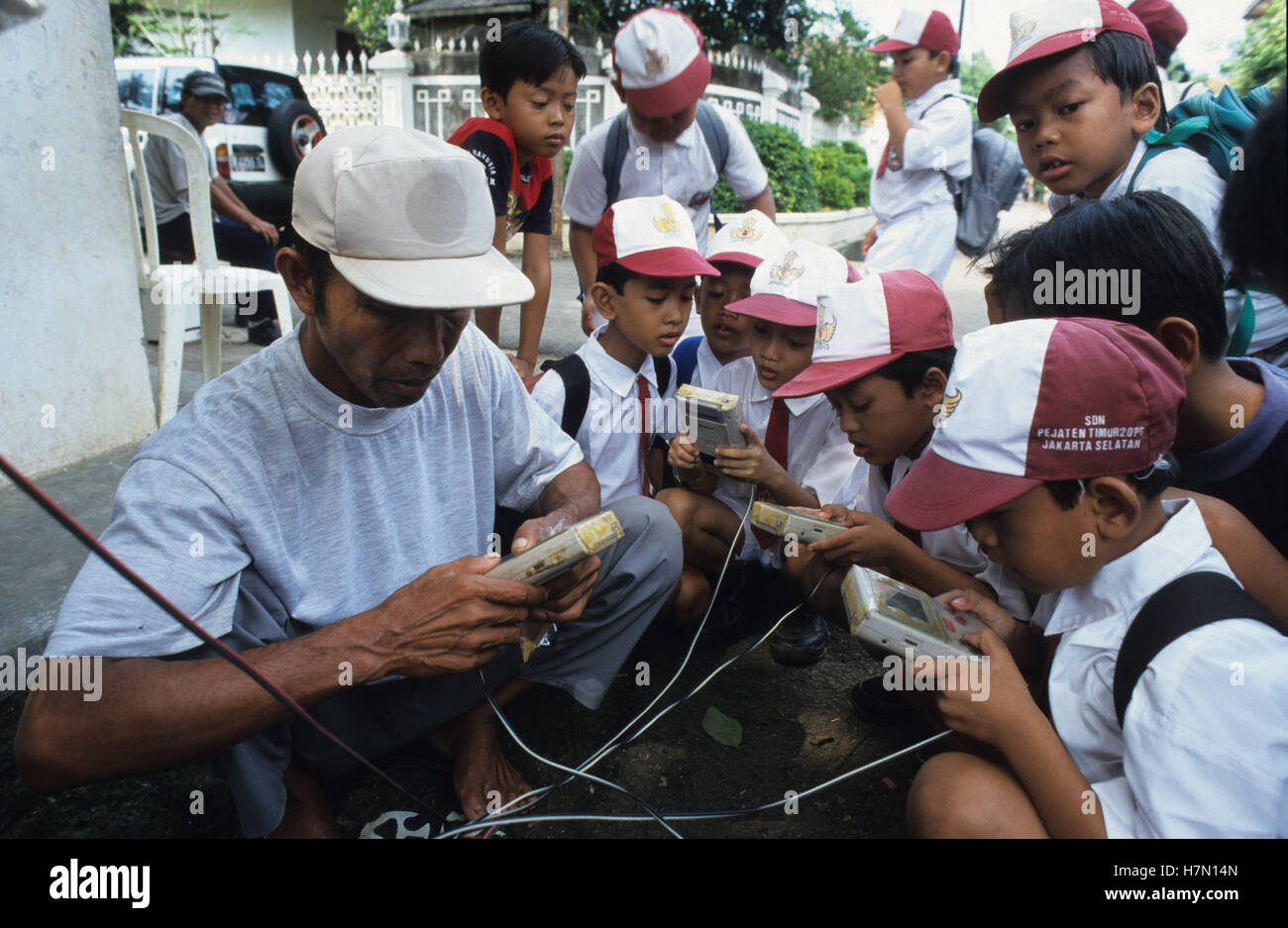 INDONÉSIE Java, Jakarta, les enfants jouant aux jeux Nintendo game boy chez Street vendeur, Game Boy est une console de jeu portable 8 bits, développée par Gunpei Yokoi Banque D'Images