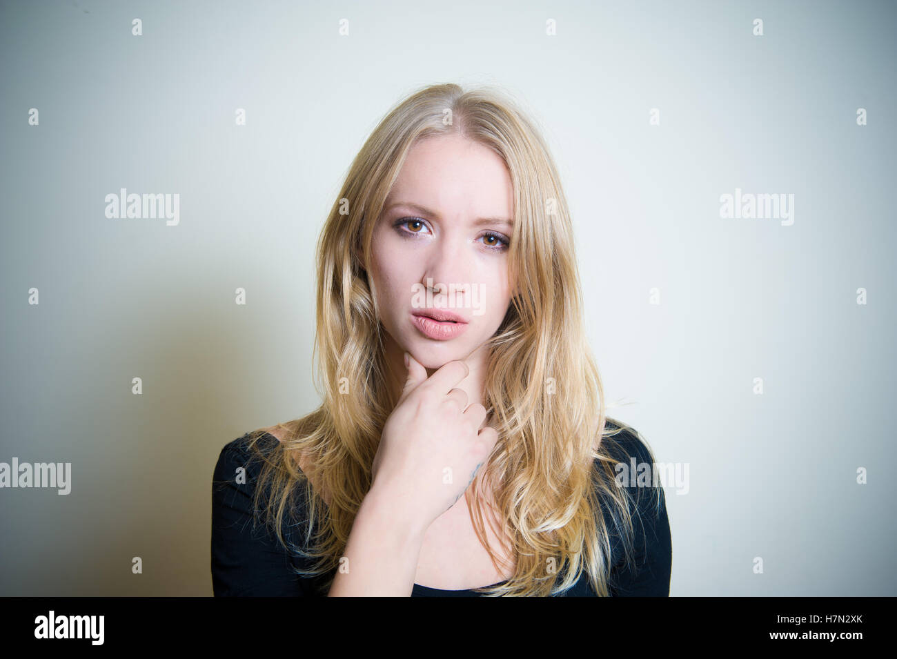 Jeune femme blonde thoughtful looking at camera, portrait Banque D'Images