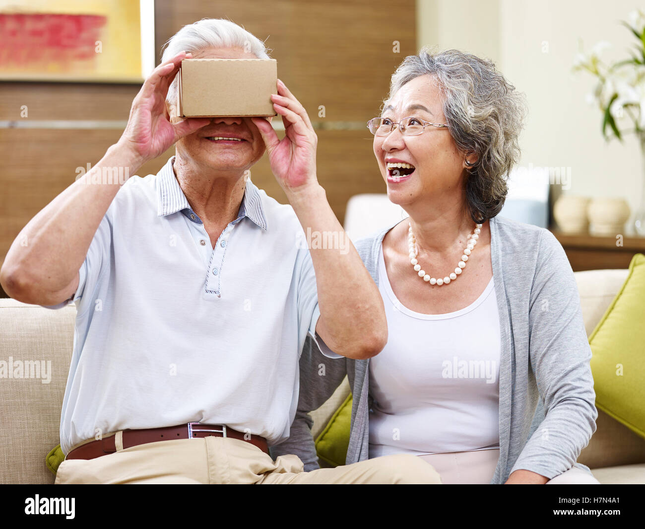 Senior asian couple émerveillé par la technologie, tout en essayant de lunettes vr Banque D'Images