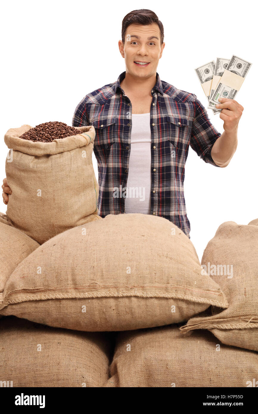 Jeune agriculteur avec sacs de toile remplis de grains de café de la détention de monnaie bundles isolé sur fond blanc Banque D'Images