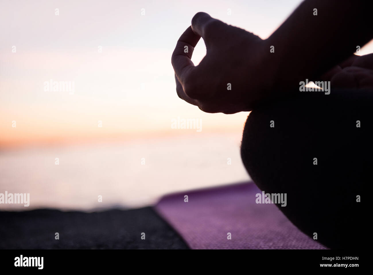 Mid section of woman performing yoga on beach Banque D'Images