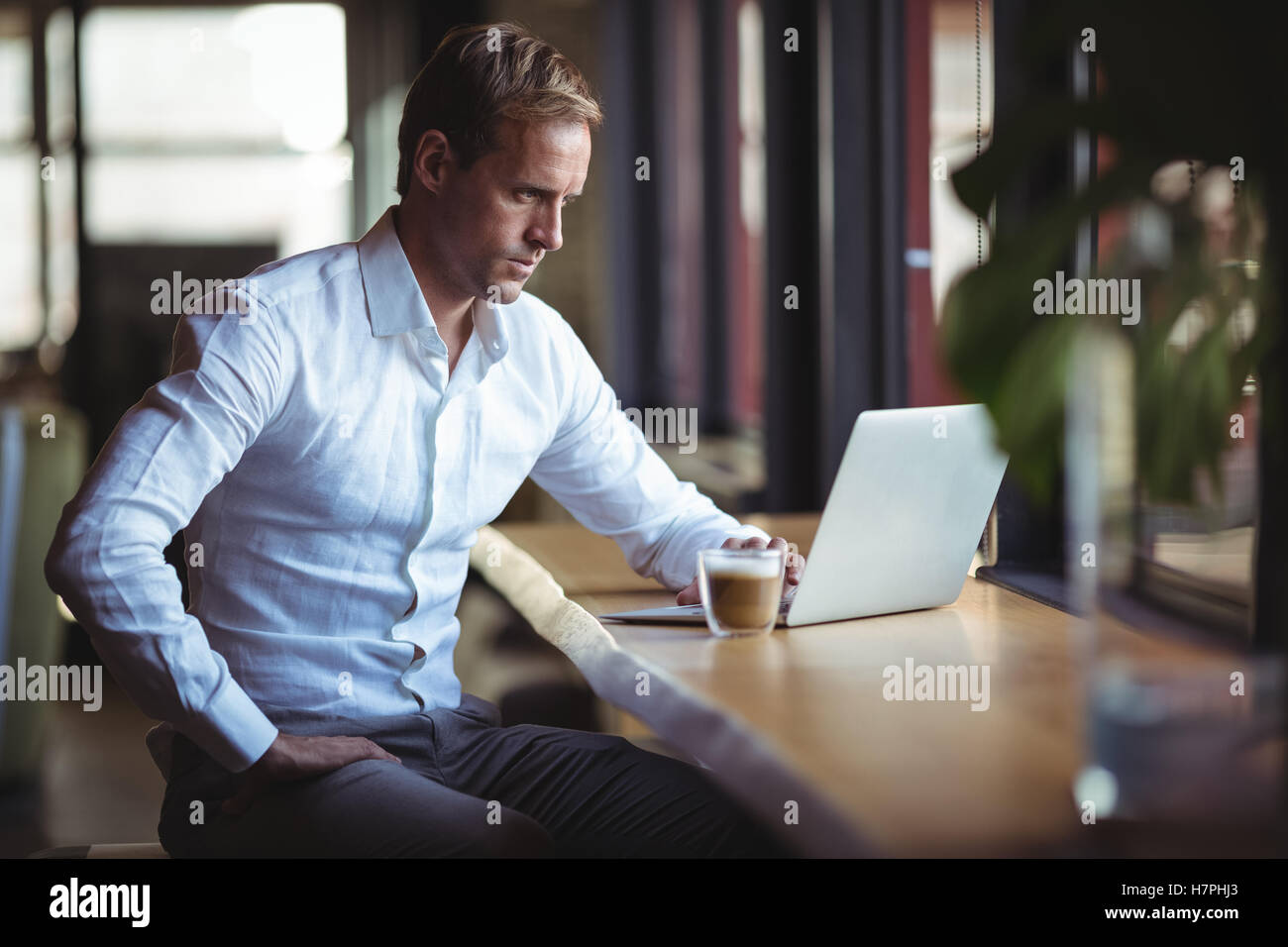 Businessman working on laptop at cafÃ© Banque D'Images