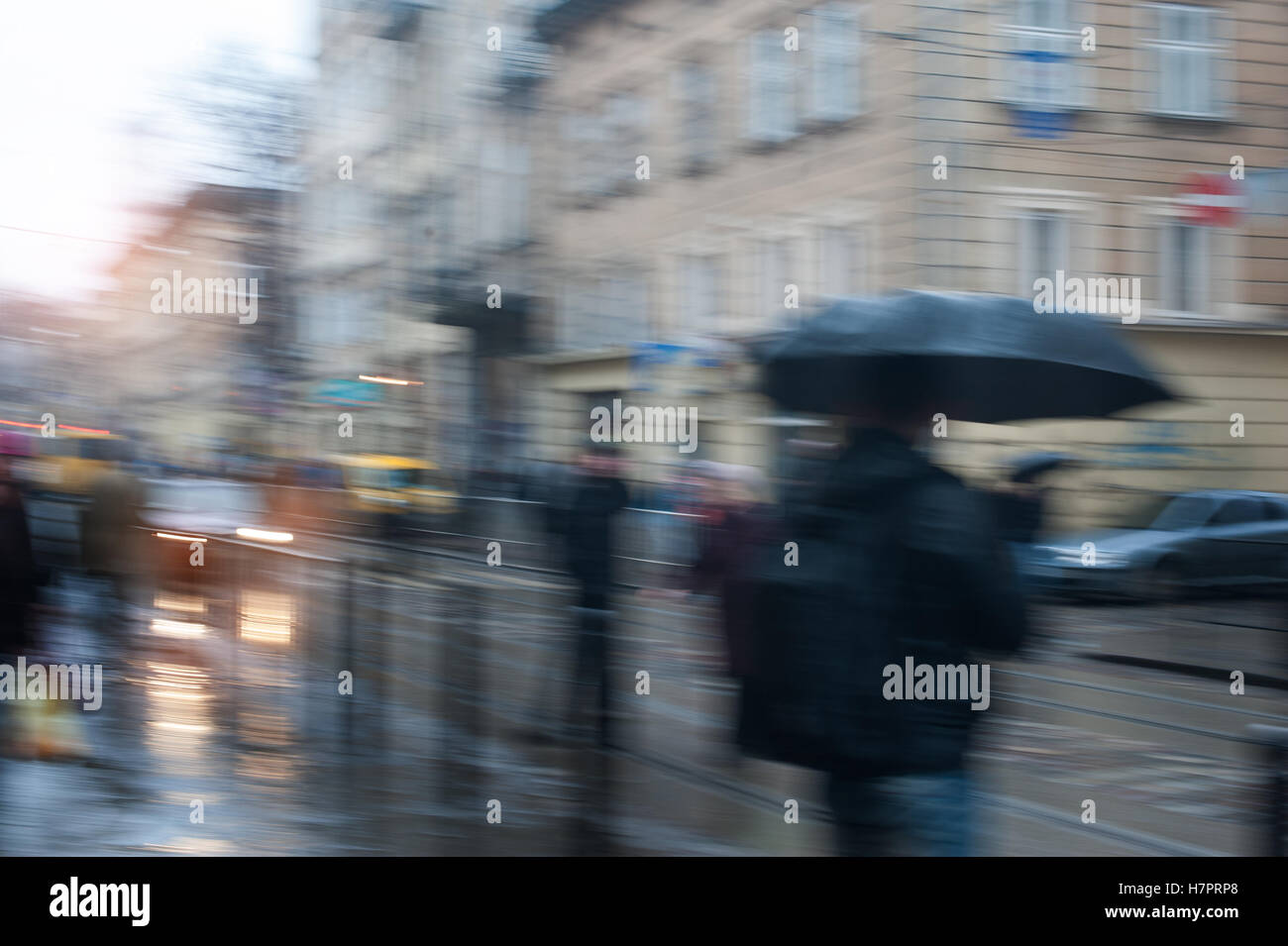 Les gens qui marchent dans la rue un jour de pluie motion blurred Banque D'Images