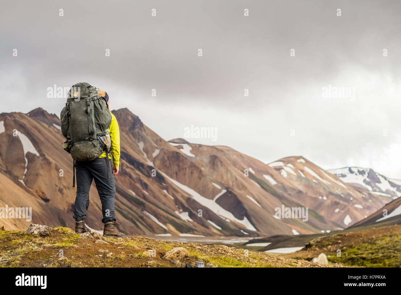 Un jeune randonneur avec vue sur les montagnes en Landmannlaugar. Banque D'Images