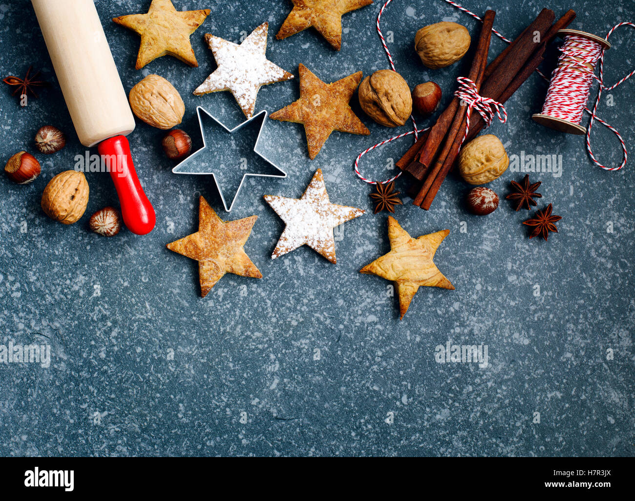 Les biscuits de Noël, broche du rouleau, cinnmoa, écrous et emporte-pièce sur fond sombre with copy space Banque D'Images