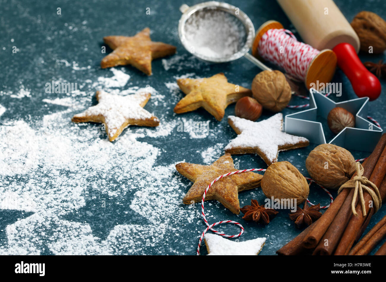 Les biscuits de Noël, broche du rouleau, cinnmon, écrous et emporte-pièce sur fond sombre Banque D'Images