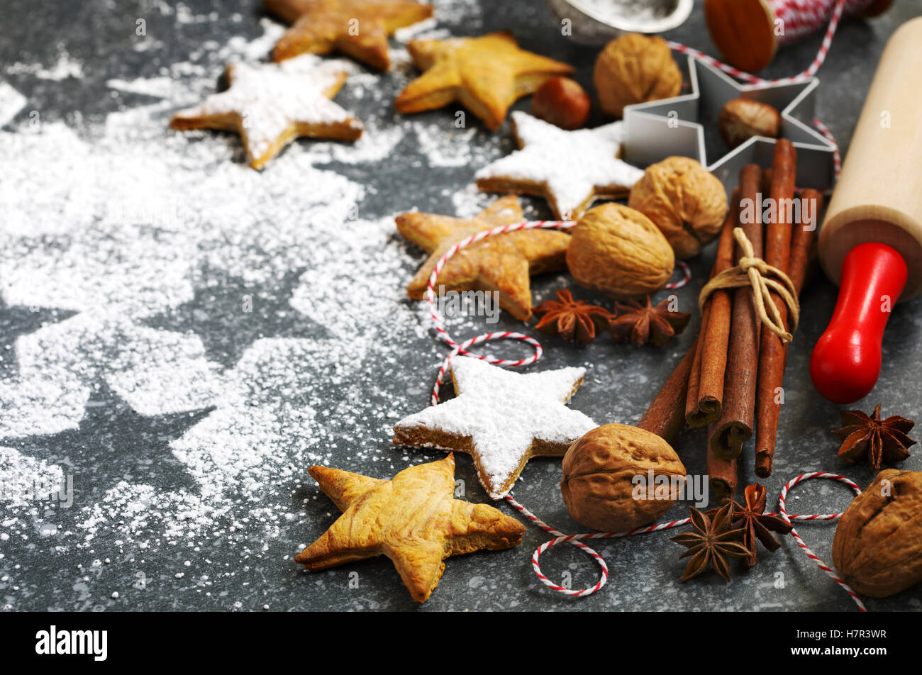 Les biscuits de Noël, broche du rouleau, cinnmon, écrous et emporte-pièce sur fond sombre Banque D'Images