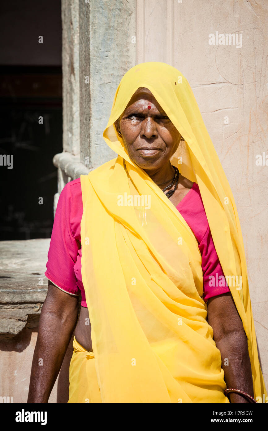 Une femme d'âge moyen de l'Inde portant un sari jaune et rouge shirt, Jaipur en Inde Banque D'Images