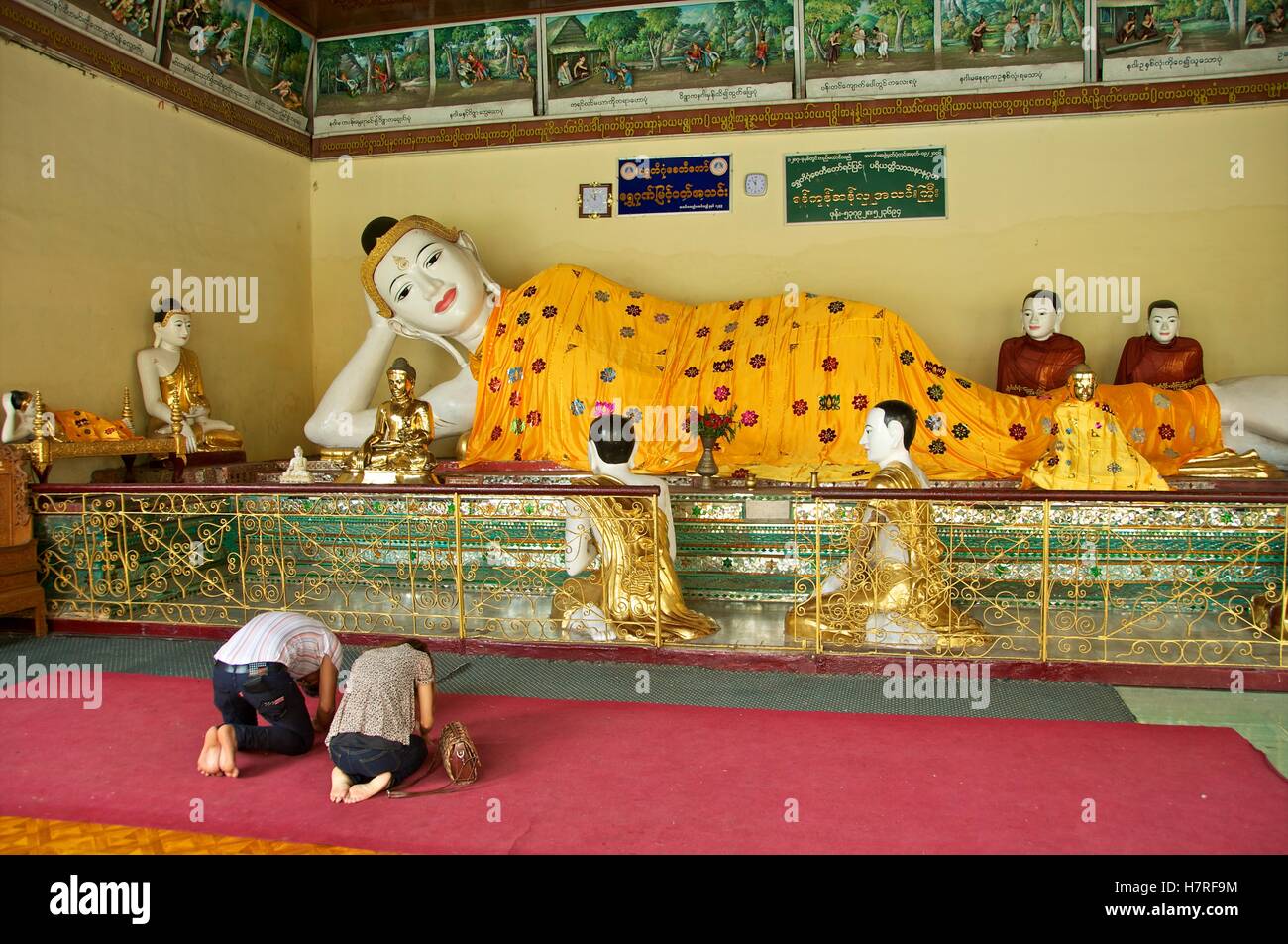 Yangon, Myanmar - 11 novembre 2014. Les bouddhistes birmans assujettissement supplémentaire en face de Bouddha à la pagode Shwedagon. Banque D'Images