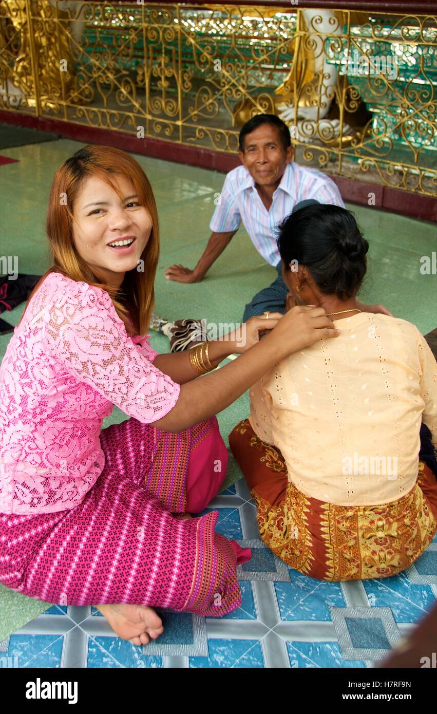 Yangon, Myanmar - 10 novembre 2014. Jeune fille donnant massage pour femme plus âgée à la pagode Shwedagon. Banque D'Images