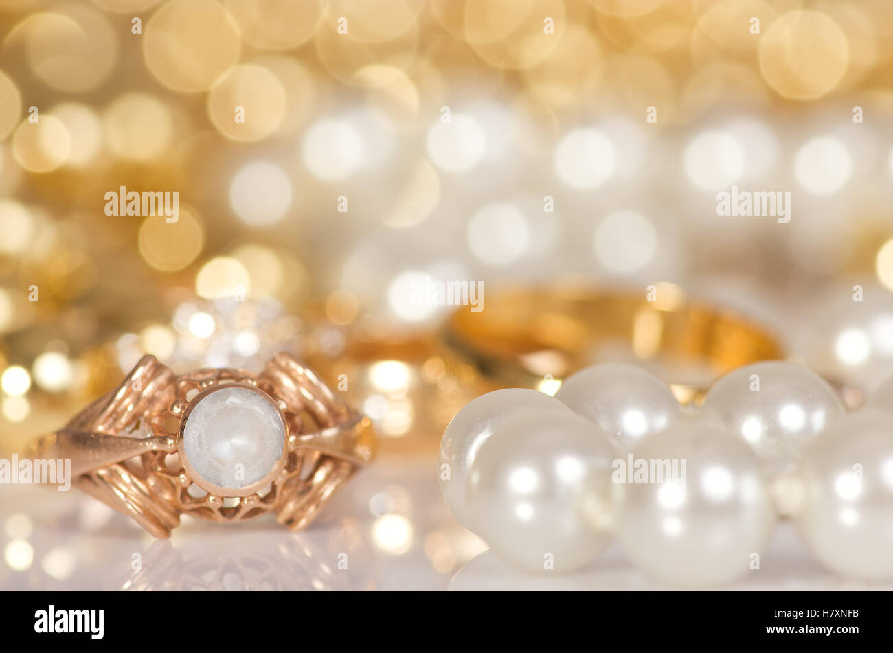 Bijoux en or et de perles sur un fond blanc de lumières dorées Photo Stock  - Alamy