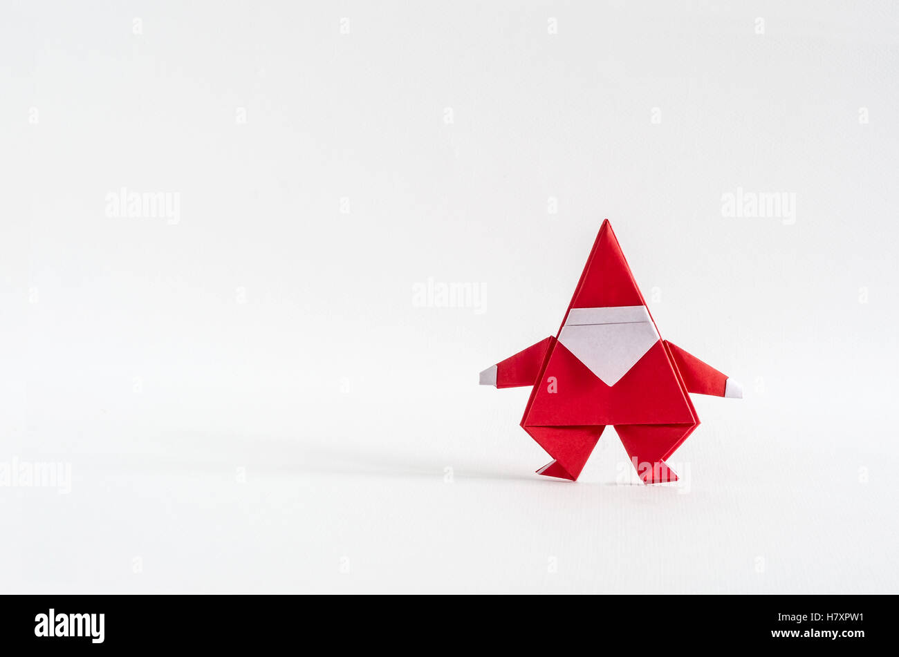 Père Noël en papier sur fond blanc. Origami Papier. Banque D'Images