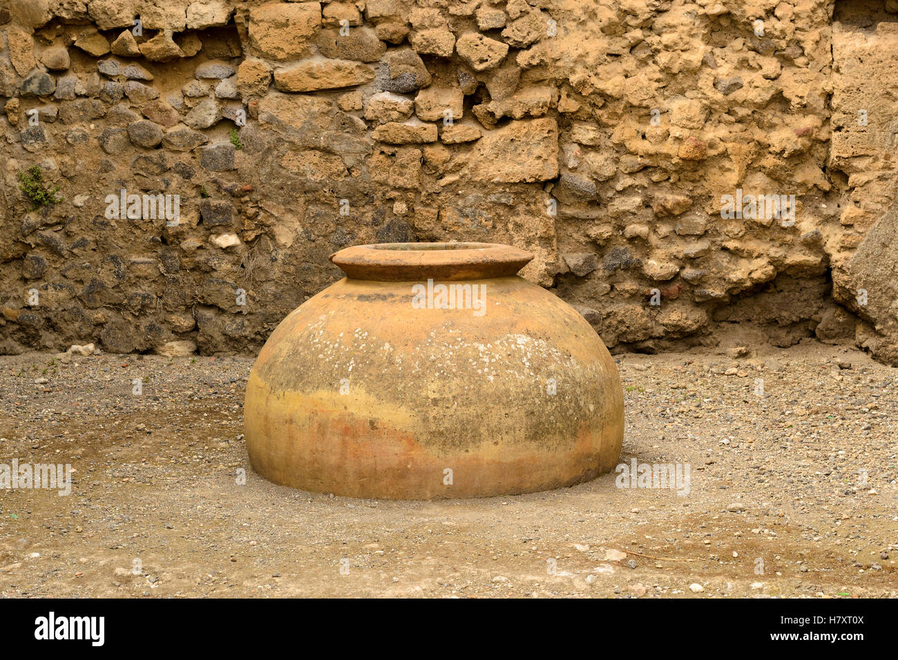 Amphores antiques sur la toile de fond d'un mur de pierre en ruines de Pompéi. Banque D'Images