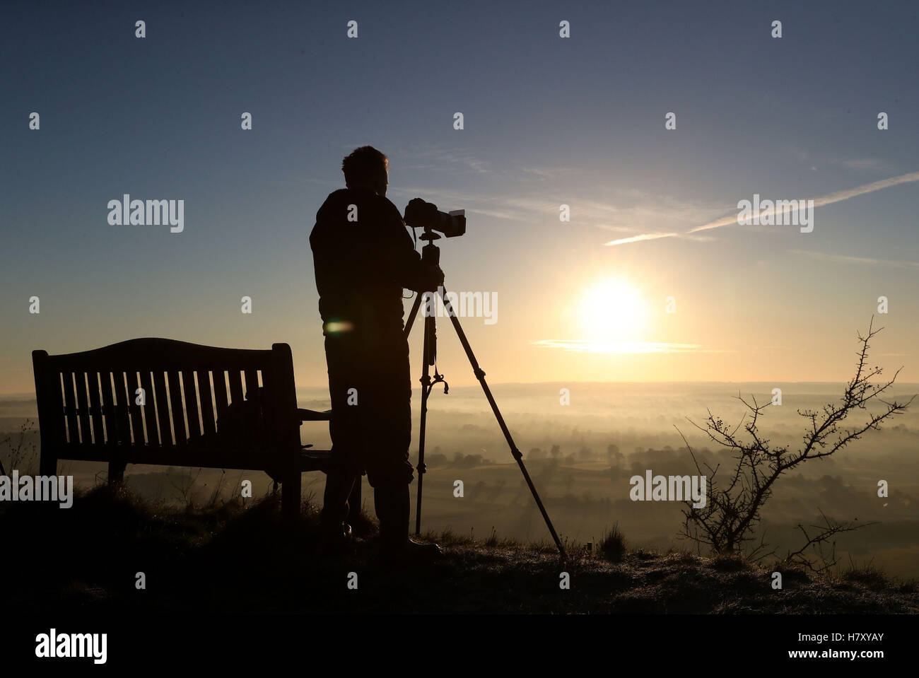 Un photographe capte le soleil qu'il s'élève au-dessus de la vallée de Pewsey près de Marlborough dans le Wiltshire, à mesure que l'hiver s'est mis à balayer au début le mardi de avec beaucoup de neige jusqu'à 15cm (6pouces) de profondeur menacé d'introduire une perturbation de voyage. Banque D'Images