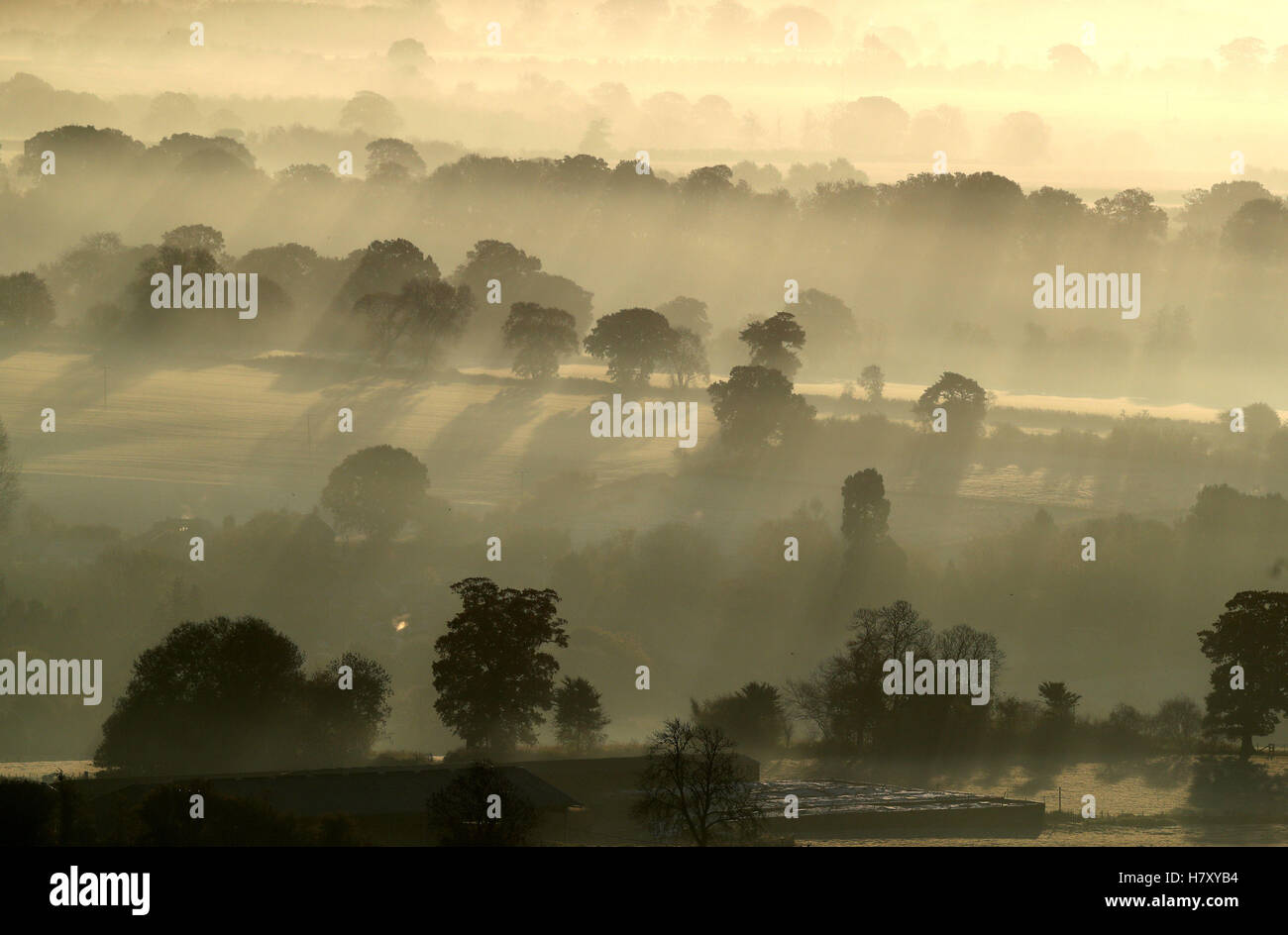 Une faible brume couvre les champs que le soleil se lève sur la vallée de Pewsey près de Marlborough dans le Wiltshire, à mesure que l'hiver s'est mis à balayer au début le mardi de avec beaucoup de neige jusqu'à 15cm (6pouces) de profondeur menacé d'introduire une perturbation de voyage. Banque D'Images
