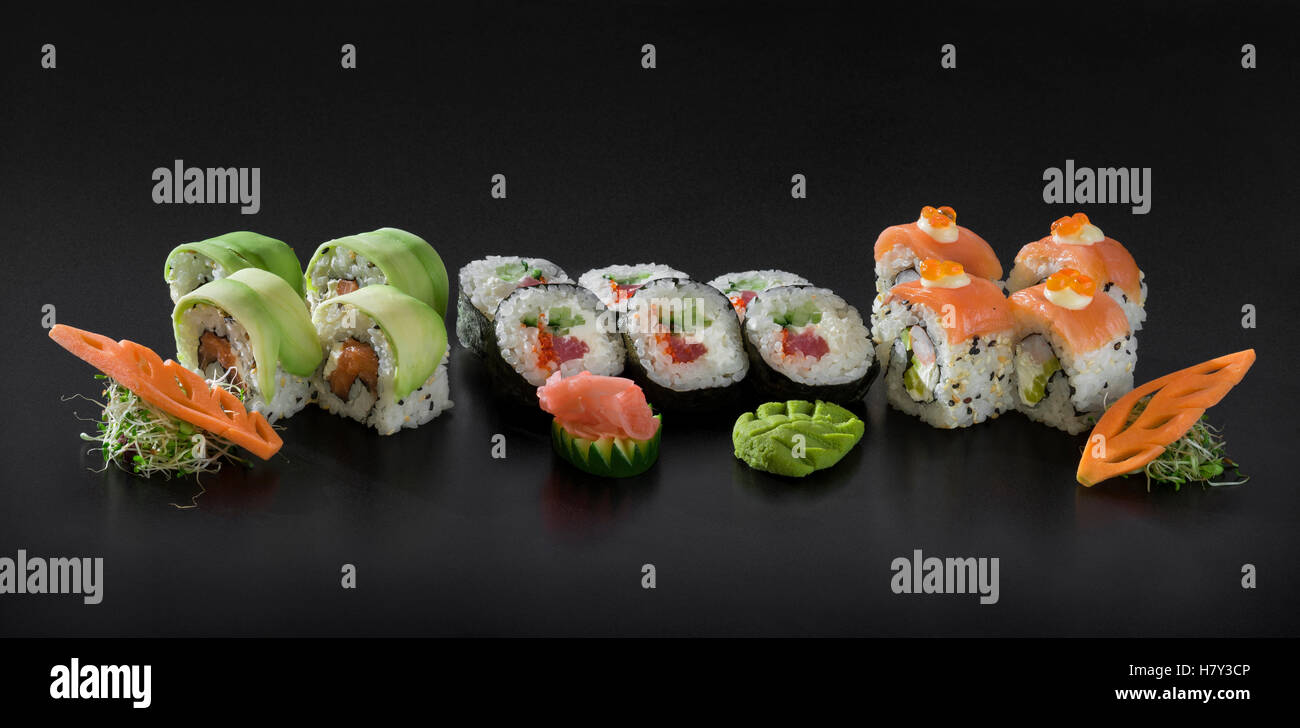Set de sushis frais. Et Uramaki sushi Hosomaki roule sur fond noir Banque D'Images