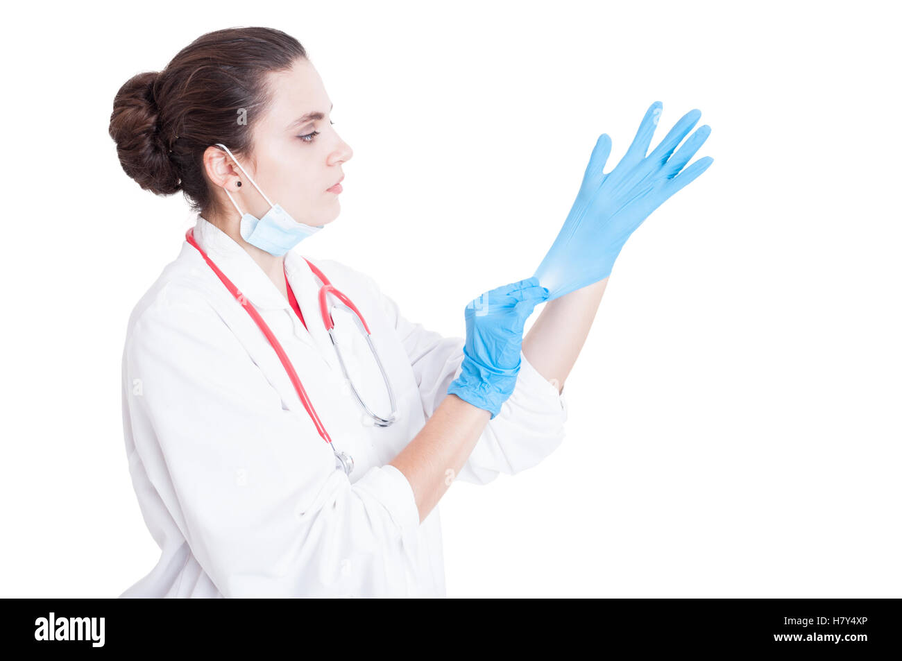 Jeune femme médecin mettre des gants et un masque lorsqu'on se préparer à une chirurgie isolé sur fond blanc Banque D'Images