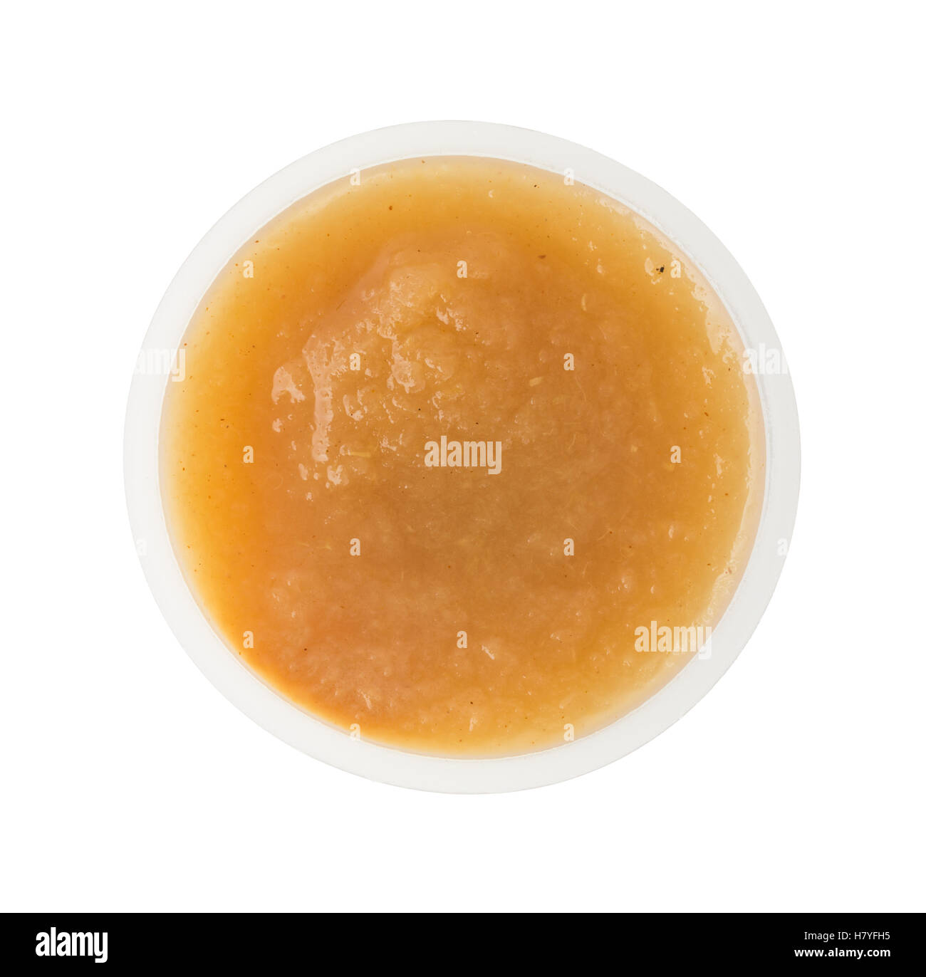 Vue de dessus d'une portion de compote de cannelle dans un petit récipient en plastique isolé sur un fond blanc. Banque D'Images