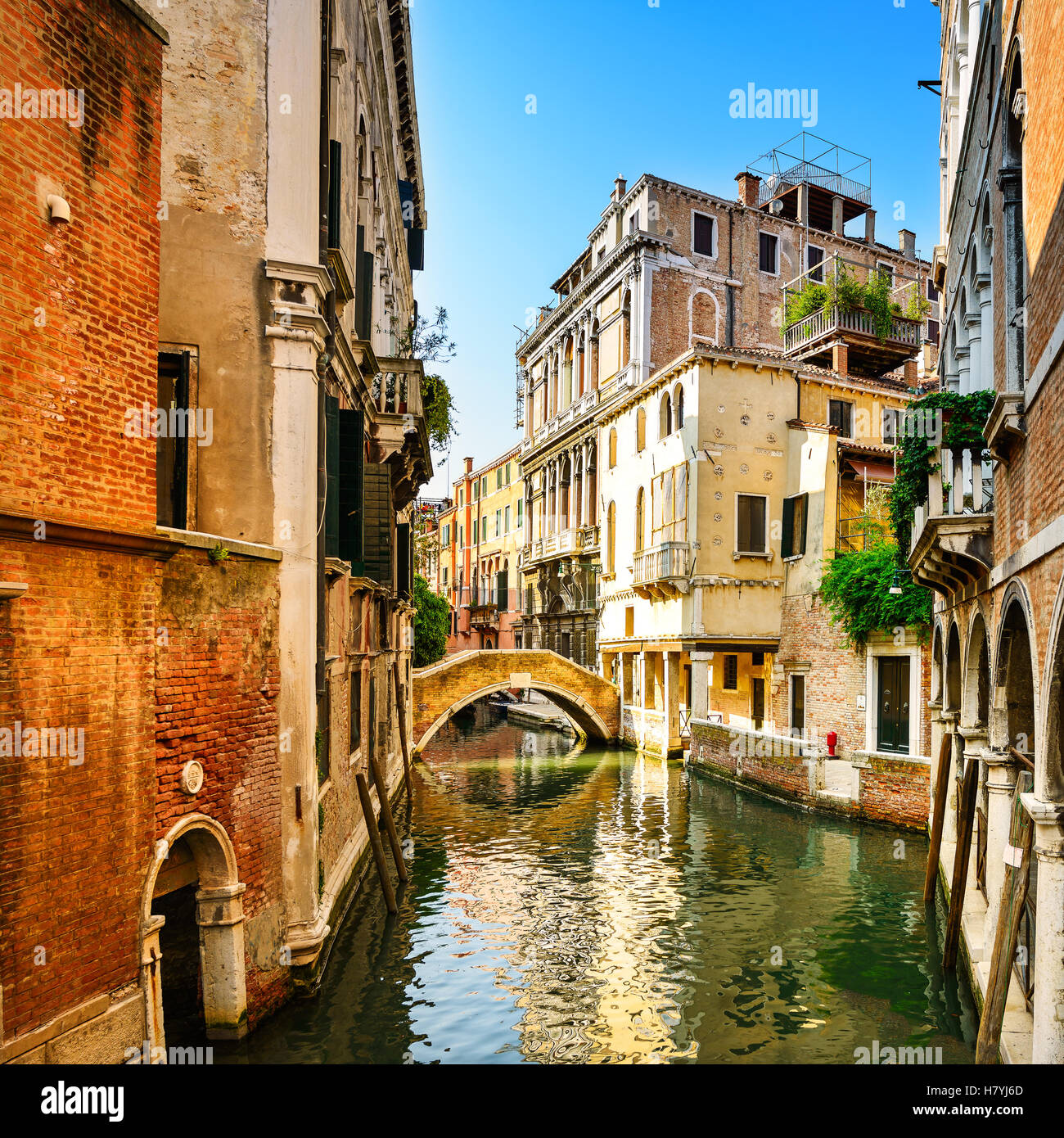 Coucher du soleil Venise cityscape, l'eau, pont du canal et des bâtiments traditionnels. L'Italie, l'Europe. Banque D'Images