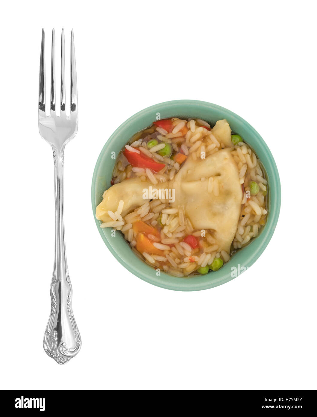 Un repas végétarien potstickers aux micro-ondes dans un bol vert avec une fourchette pour le côté isolé sur un fond blanc. Banque D'Images