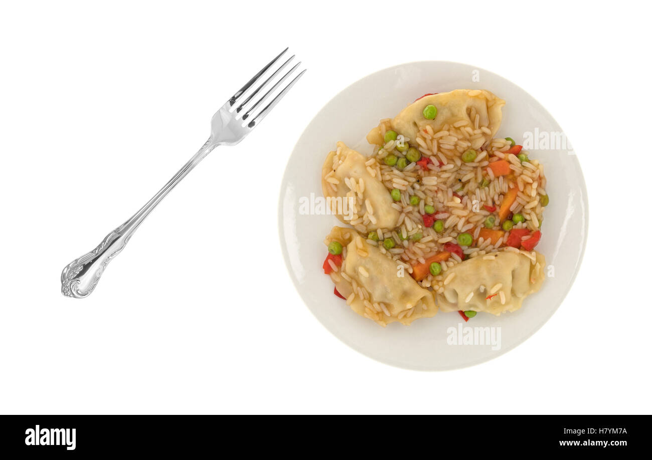 Un repas végétarien potstickers aux micro-ondes sur une assiette avec une fourchette pour le côté isolé sur un fond blanc. Banque D'Images