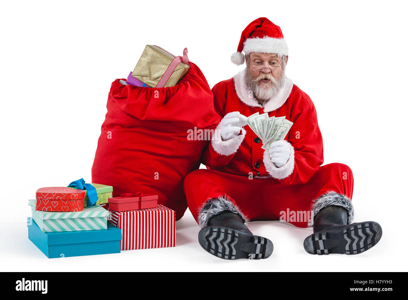 Père Noël assis à côté d'un bureau de dépouillement cadeaux remarque Banque D'Images