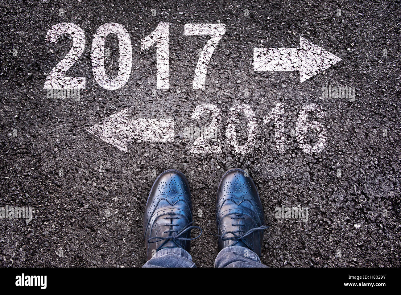 2017 et 2017 écrit sur une route asphaltée, les jambes en arrière-plan Banque D'Images