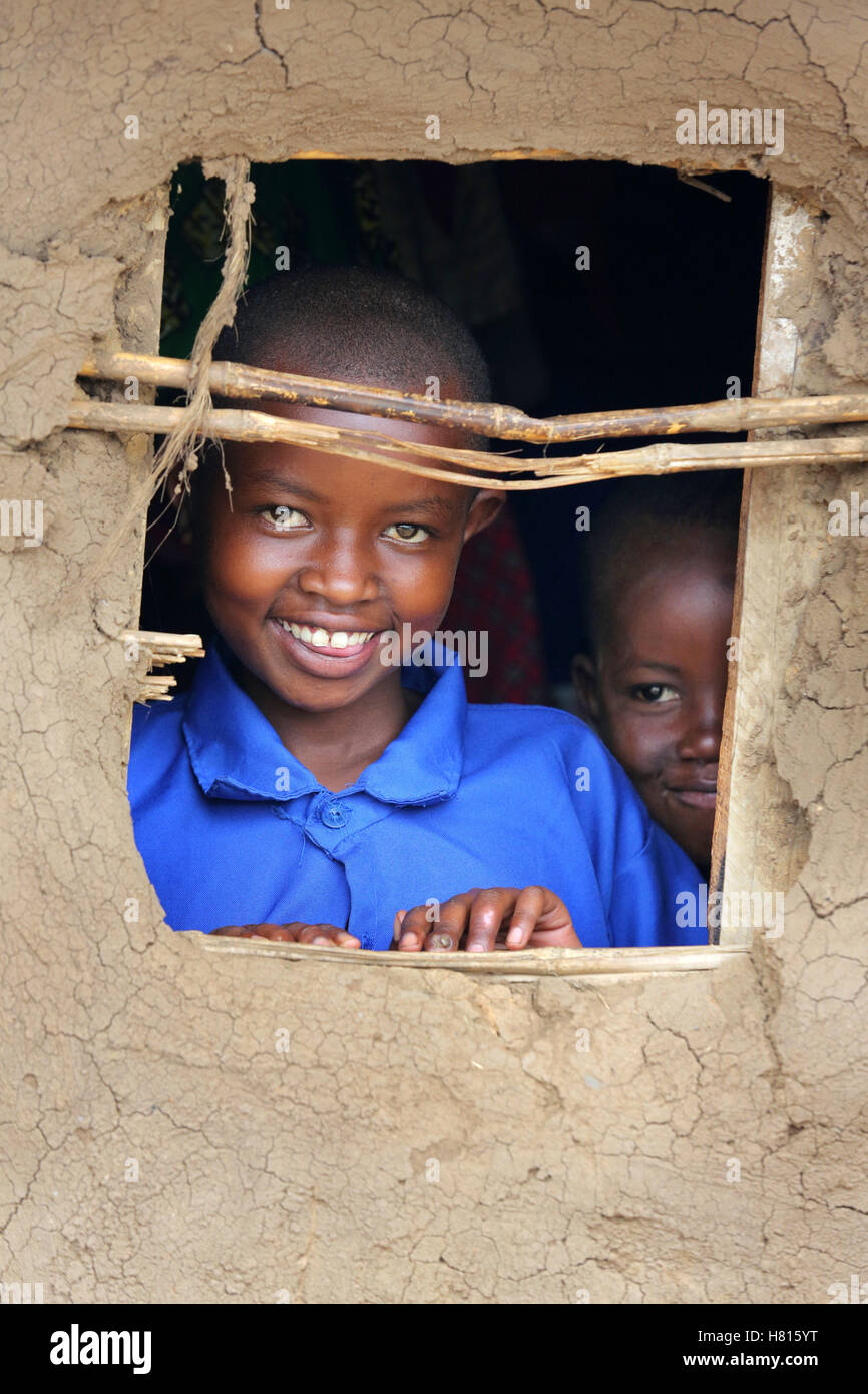 Les filles à la recherche par la fenêtre d'une hutte de boue, le Rwanda, l'Afrique Banque D'Images