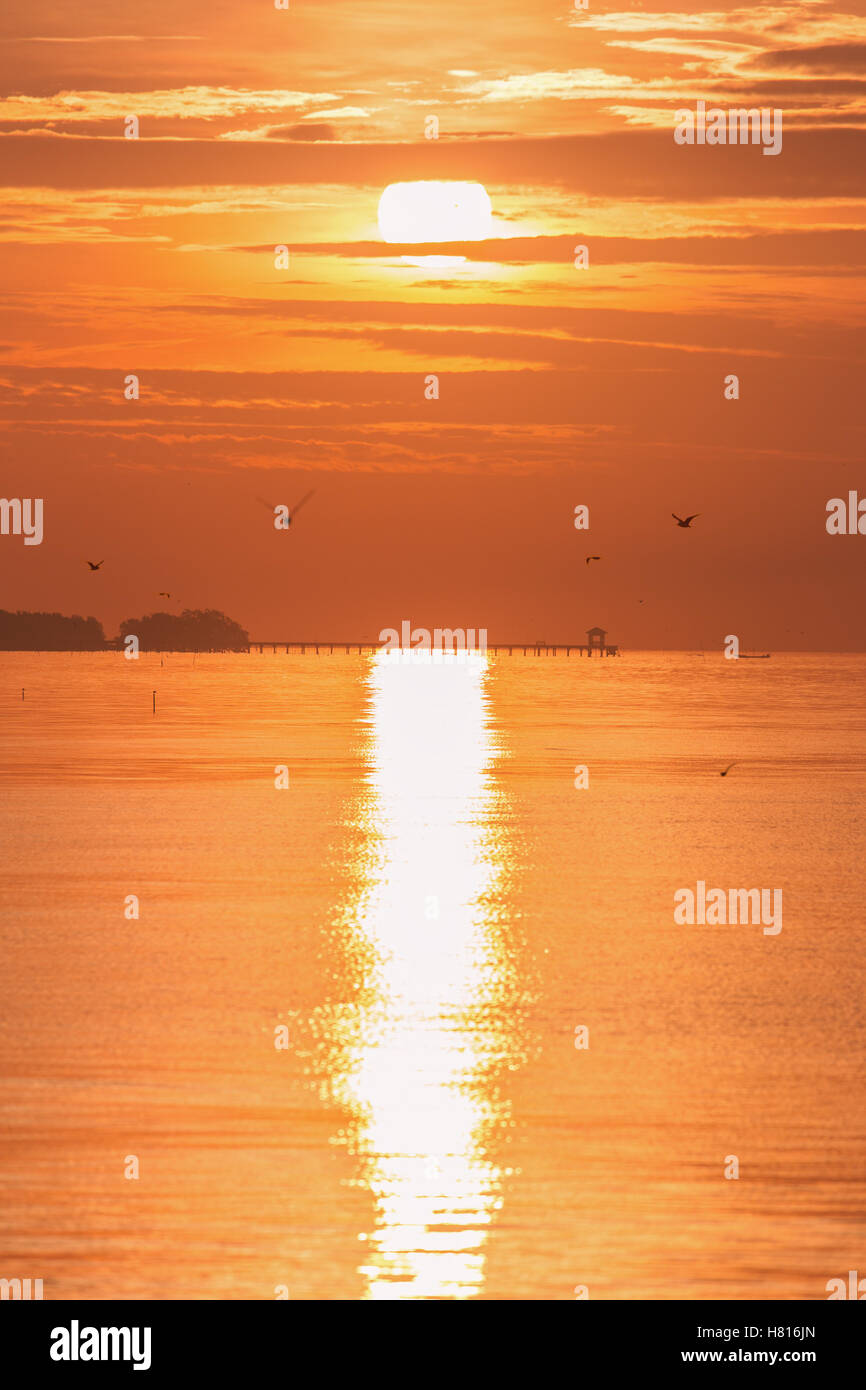 Scène verticale du lever du soleil à Bangpu, Samutprakarn de la Thaïlande au ciel nuageux. Reflétant la lumière du soleil mer plage surface comme longue ligne Banque D'Images