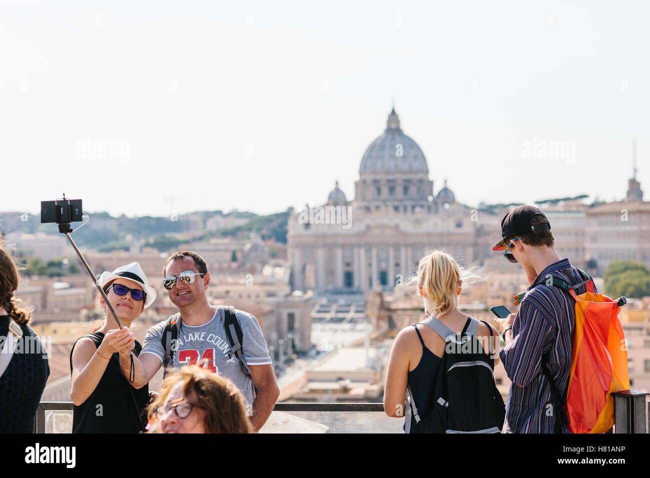 À Rome, un couple avec des lunettes de prendre un avec un bâton selfies selfies avec St Peters Square et le Vatican dans l'arrière-plan. Banque D'Images