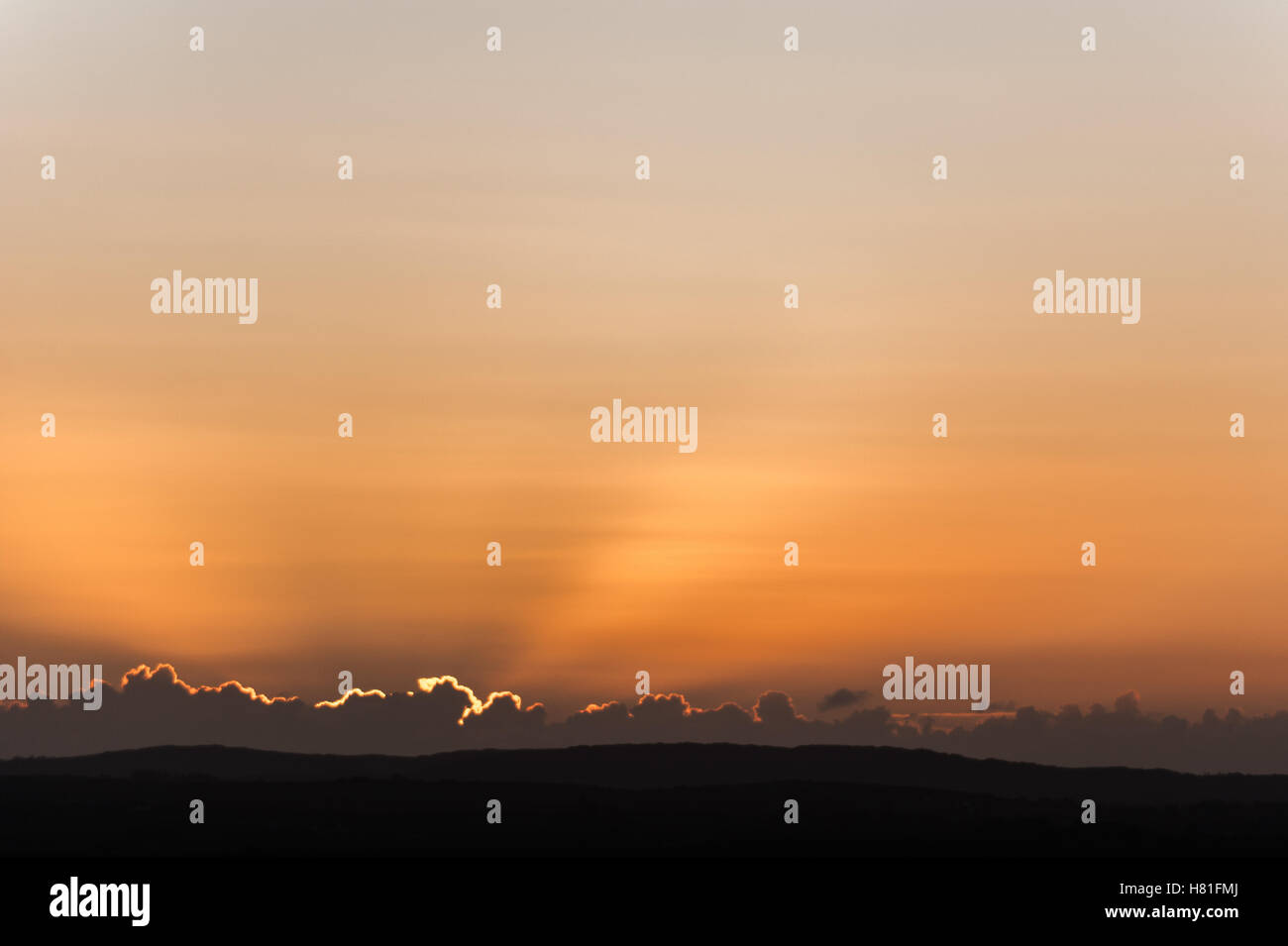 Rayons de soleil apparaissent derrière les nuages que le soleil se lève sur un froid matin d'automne. Banque D'Images