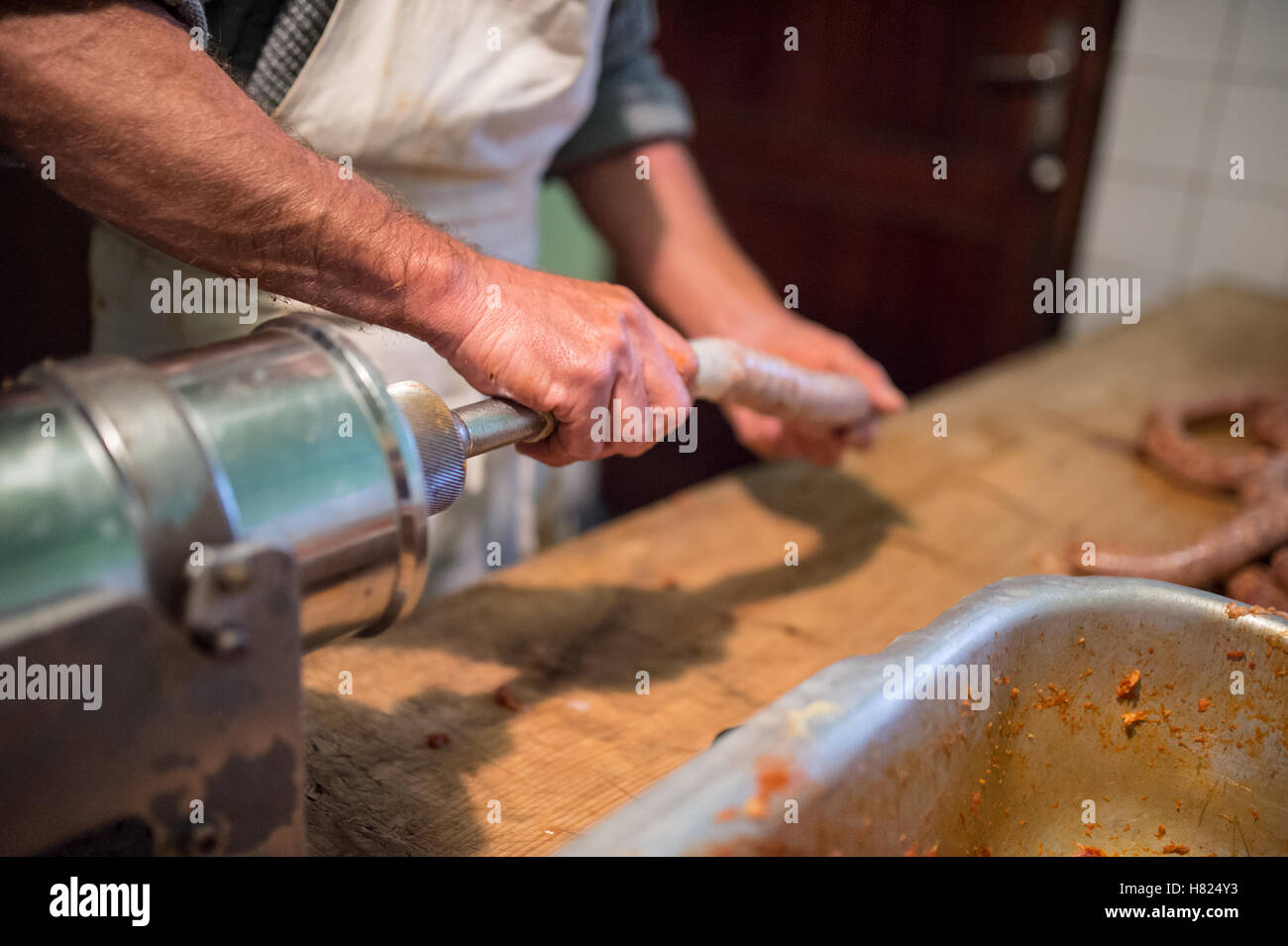 L'homme préparer des saucisses la manière traditionnelle en utilisant des saucisses de remplissage. Banque D'Images