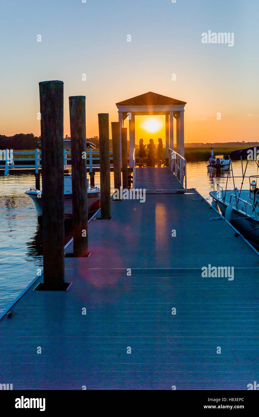 Trois amis on dock at sunset ; baie intérieure & marais près de Charleston, Caroline du Sud, USA Banque D'Images