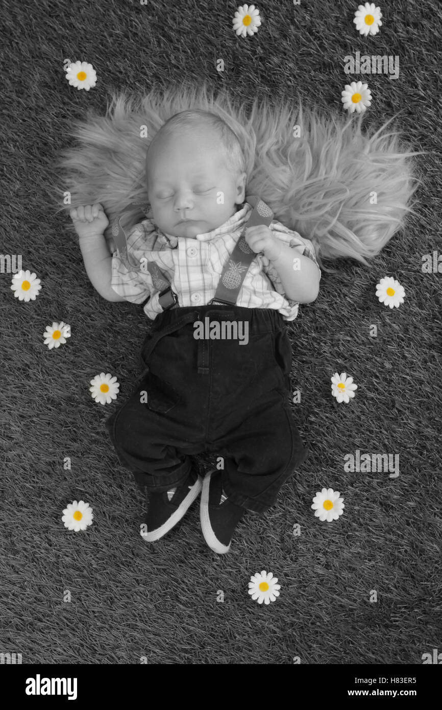 Bébé nouveau-né garçon endormi sur l'herbe Banque D'Images