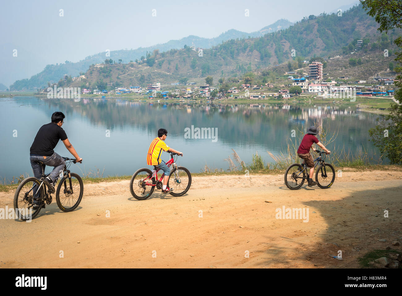 Des vélos en famille longent le lac de Phewa près de Pokhara, district de Kaski, au Népal. Banque D'Images