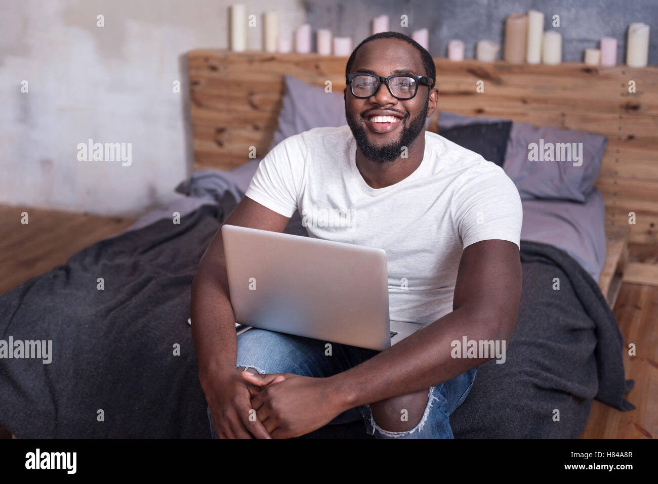 L'homme joyeux holding laptop dans la chambre Banque D'Images