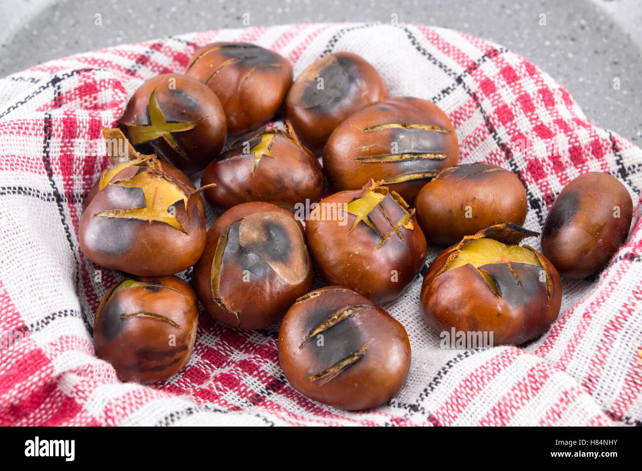 Châtaignes grillées sur un plat de cuisson en pierre Banque D'Images