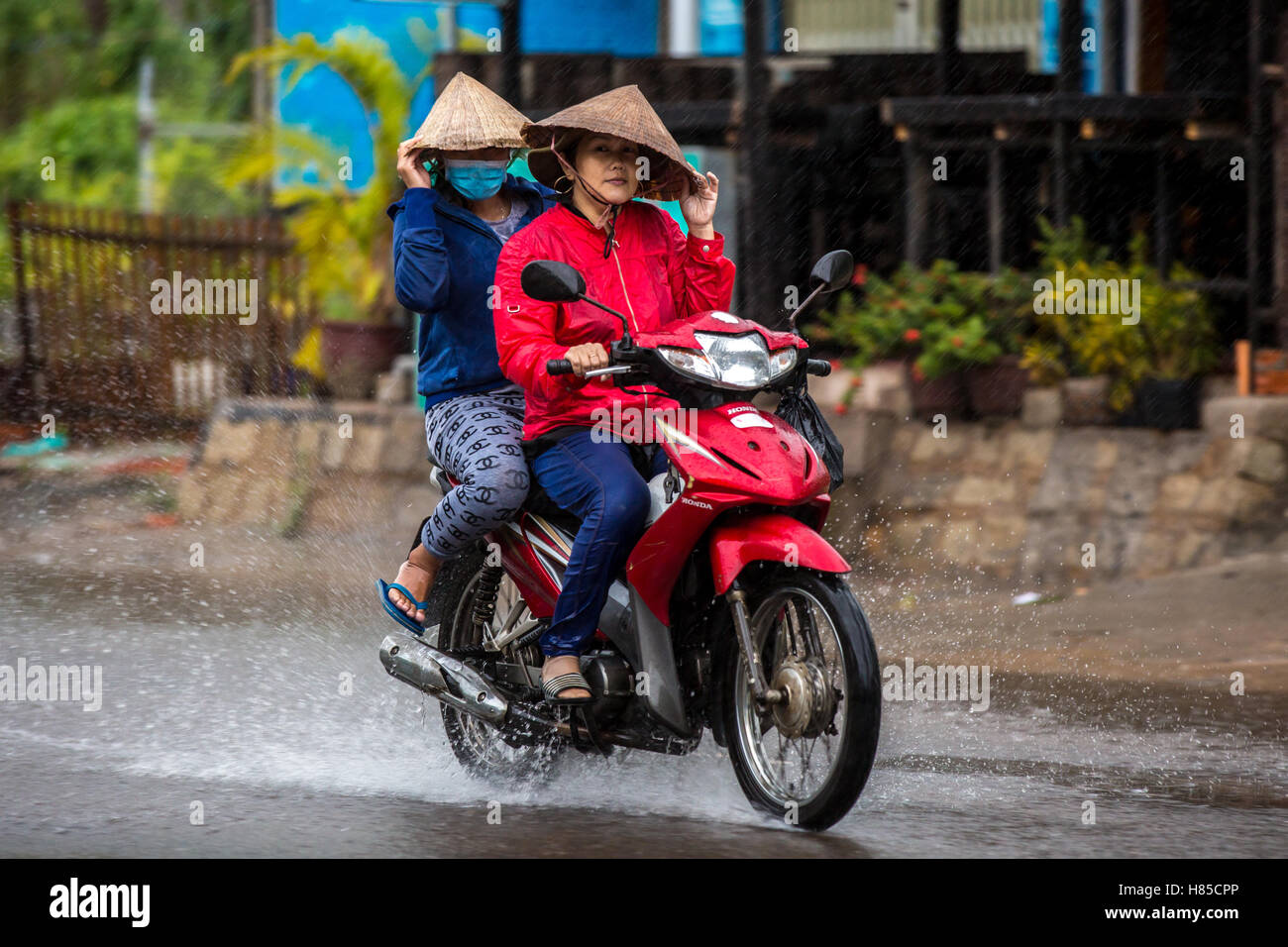 MUI NE, VIETNAM - 3 NOVEMBRE 2016 : un motocycliste rides le long d'une rue inondée le 3 novembre 2016 à Mui Ne, Vietnam. Banque D'Images