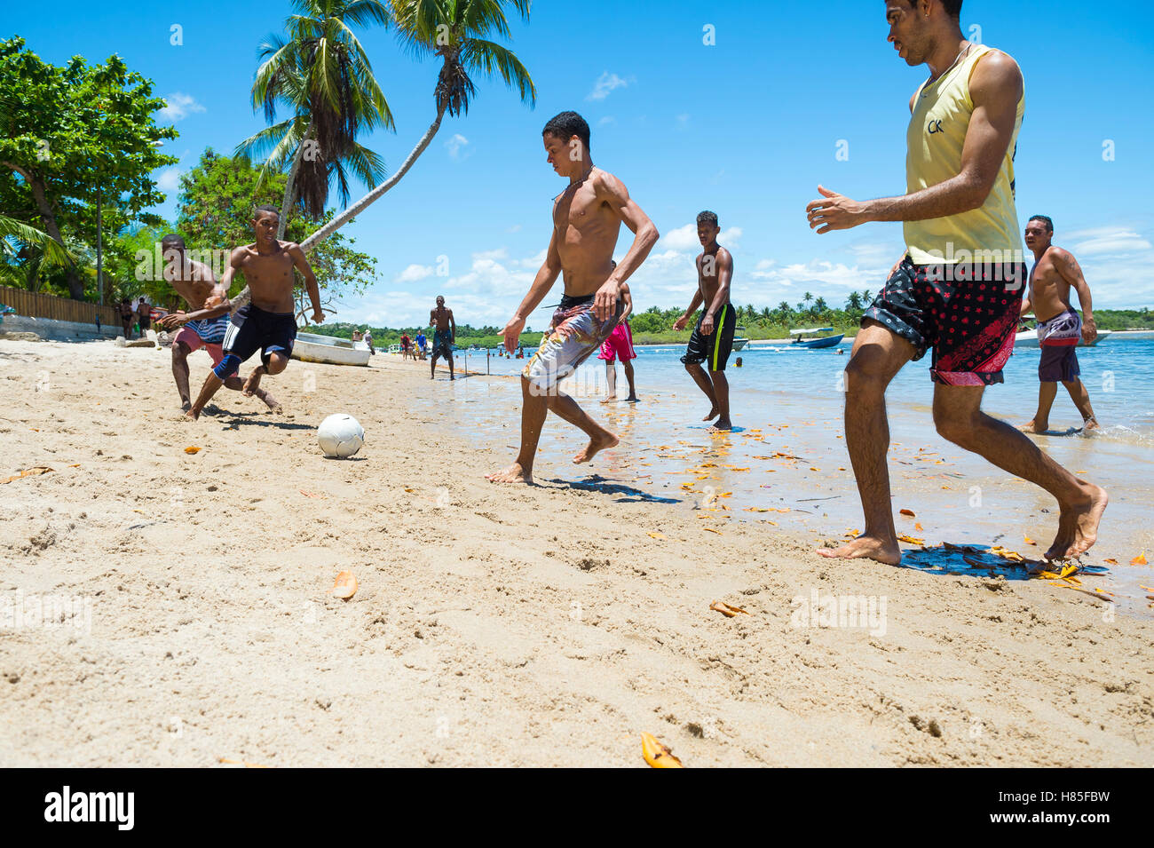 BAHIA, BRÉSIL - 7 février 2016 : un groupe de jeunes hommes musclés brésilien jouer au foot de plage sur le bord d'une plage éloignée. Banque D'Images