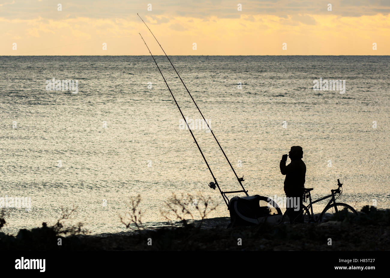 Silhouette de quelqu'un qui pêche en mer. Banque D'Images