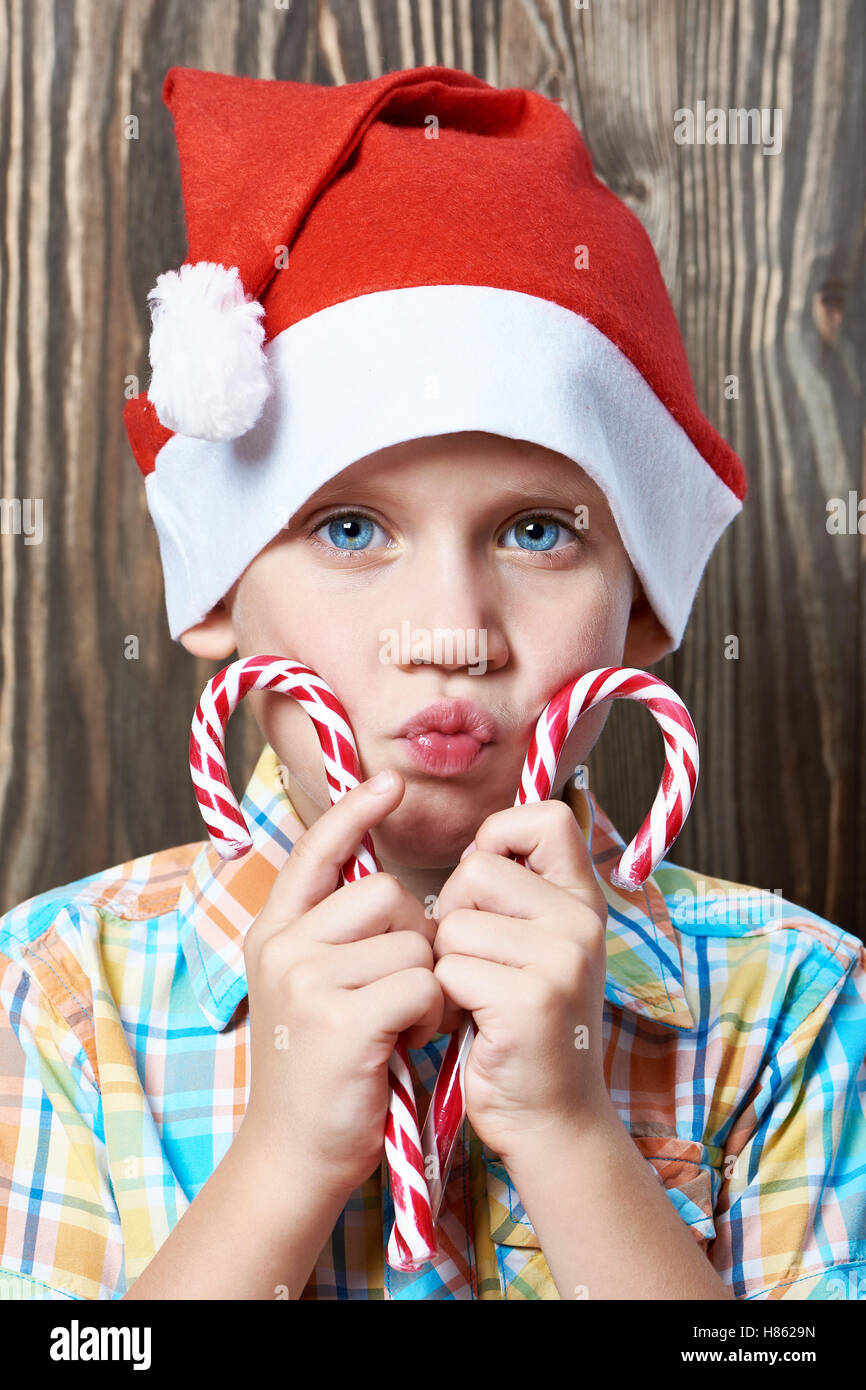 Petit garçon dans une nouvelle année, le bonnet rouge avec sucettes de Noël Banque D'Images