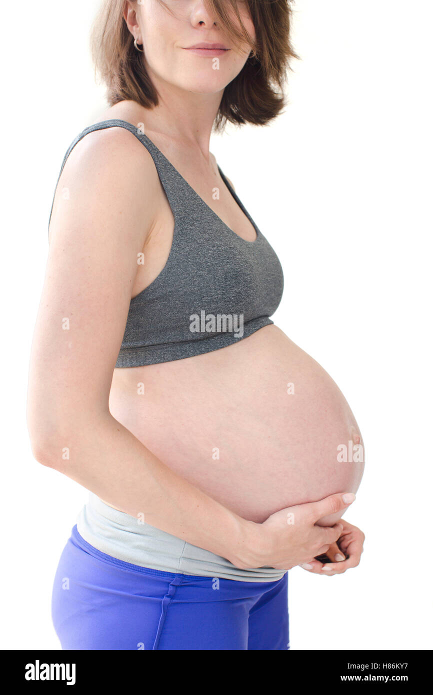 Close-up ventre d'une femme enceinte dans les vêtements de sport Banque D'Images