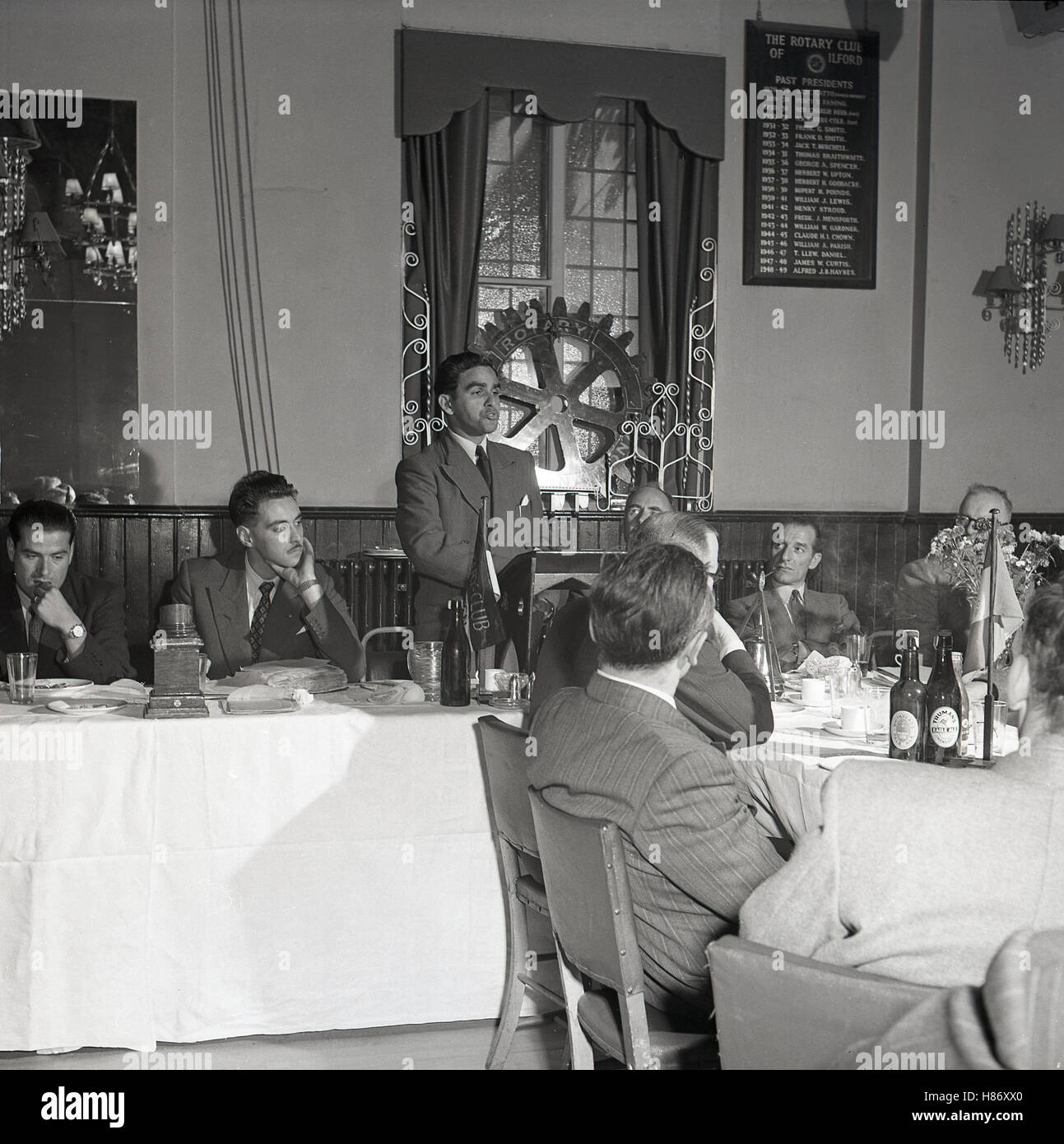 1950, historiques, Gentleman debout en train de faire un discours lors d'un dîner du Rotary Club de Ilford. Ces clubs réunissent des entreprises et des professions libérales afin de fournir des services humanitaires et d'encourager des normes éthiques élevées. Banque D'Images