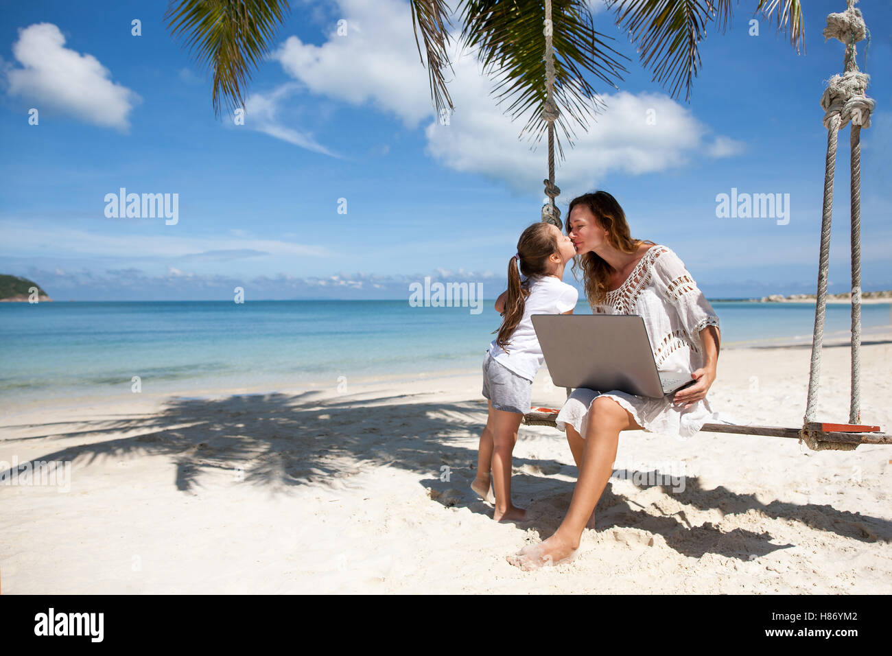 Offres et demandes des femmes sur une plage avec portable Banque D'Images