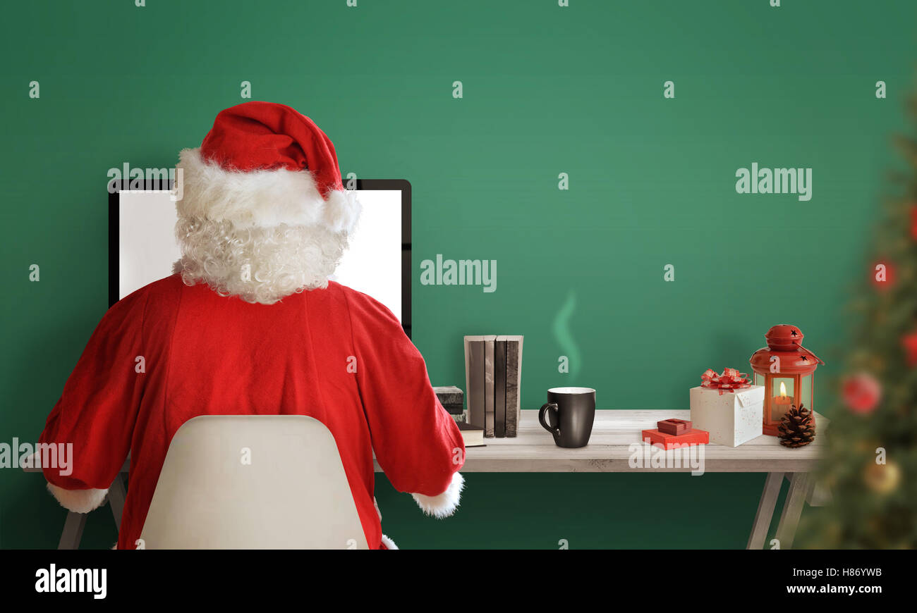 Les achats en ligne du père Noël pendant la vente de Noël. Cadeaux de Noël, Arbre, plateau, des livres et des décorations de table. Espace libre fo Banque D'Images