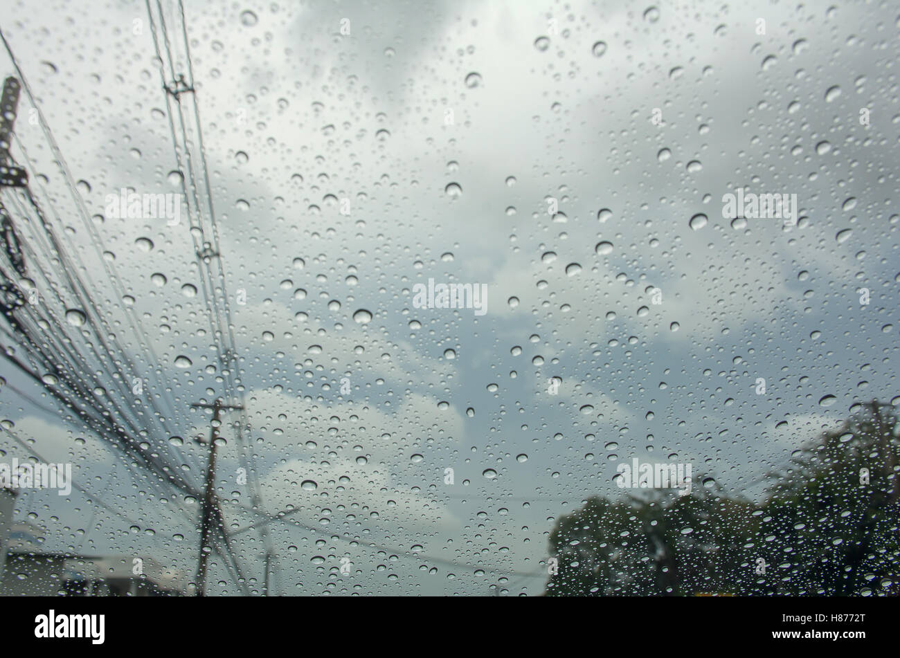 Chute de pluie sur la voiture vitre avec poteau et nuages dans le ciel Banque D'Images