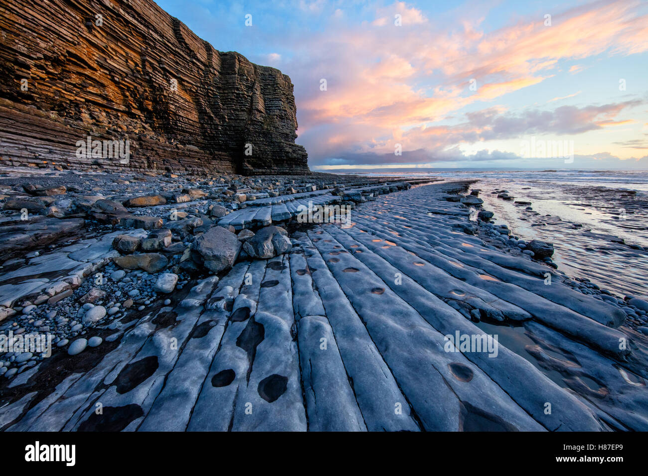 Coucher du soleil à Nash et Point vague-cut lias jurassique lapiez sur la côte du Glamorgan South Wales UK Banque D'Images