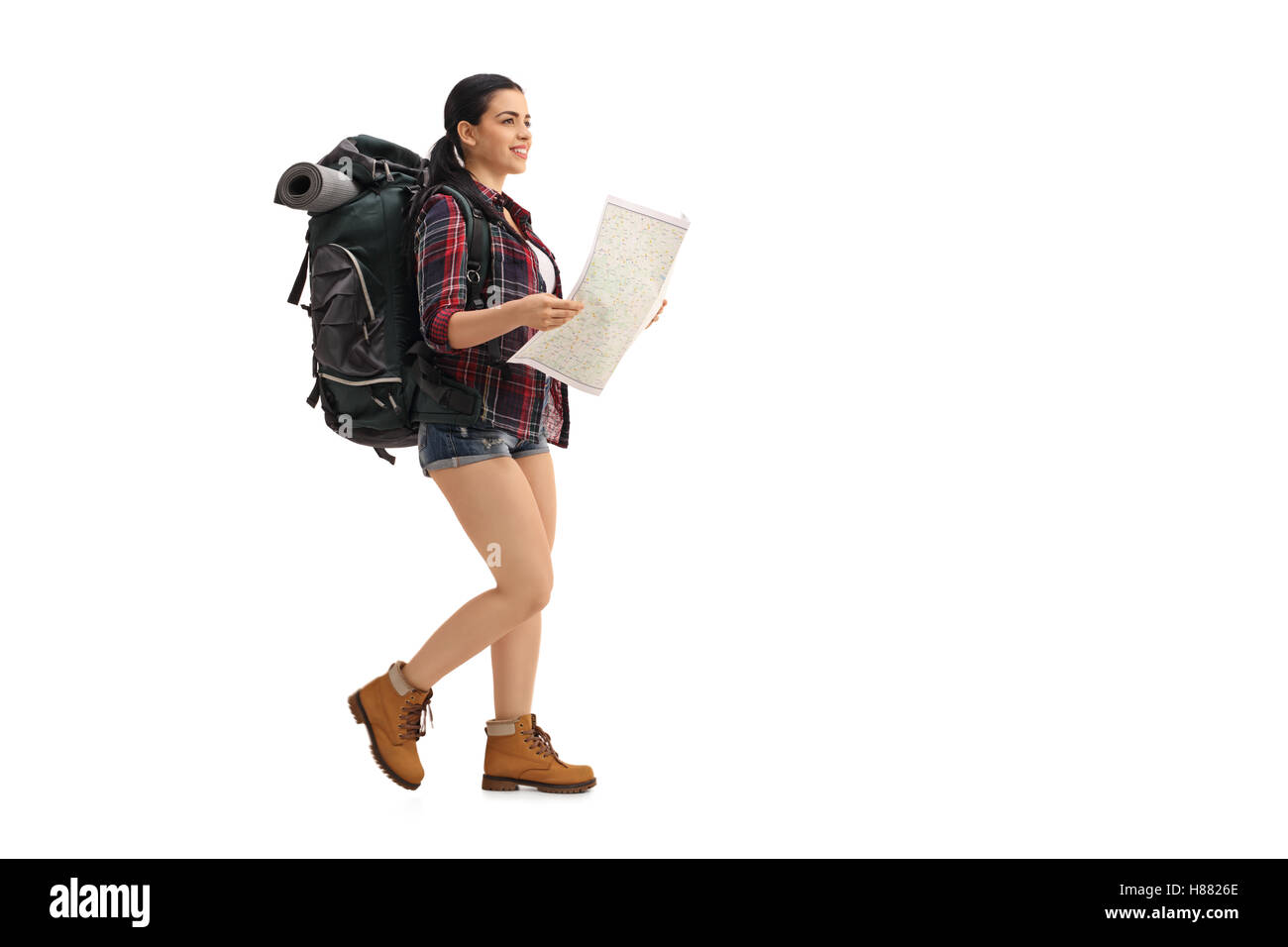 Profil complet tiré d'un female hiker walking et tenant une carte générique isolé sur fond blanc Banque D'Images